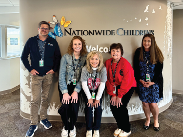 teachers standing in front of nationwide childrens sign